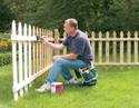 Man using Garden Rocker Seat to paint a picket fence