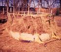 Seen welded and braced to a standard big-round-bale pasture feeder is the parallel 2-inch-diameter steel tube segments into which the tractor-mounted vale spears are inserted.