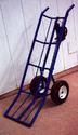 Seen is the two-wheeled, two-handled, dolly-type cart (its lower part bent about 45 degrees) with the hand-cranked winch assembly located between the handles.