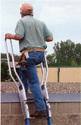 With hand holding onto this productâ€™s flared-out railing, an adult male steps from the top ladder rungs onto a flat roof.
