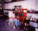 An adult male in a wheelchair retrieves an item from one of the drawers of this easy-to-access, right-height tool chest.