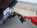 Picture of pickup truck bumper on the left with the Hitchrific Reel-Quik Hitch installed and the tongue of a red trailer shown on the right.