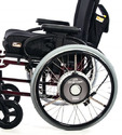 Black wheelchair with large hubs on wheels that are powered by a battery under the back of the seat.