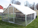 All-aluminum rectangular walk-in chicken coop with aluminum screening on sides & white tarp cover as roof. 2 wheels on back for portability.