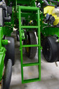 Green metal ladder attached to back of John Deere green and yellow planter