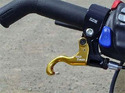 Left handlbar of an ATV with a curved gold finger throttle attached.