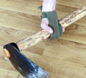 Hand with Homemade Fabric-Wrap Gripping Aid gripping an axe handle with wood floor as background.