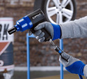 Gloved hands in a tire shop coupling an air hose to an air gun using the Prevost Air Hose Quick Safety Coupler