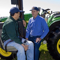 Farmer with a disability converses with another farmer