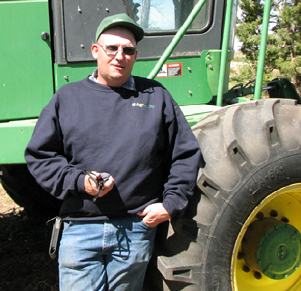 Dustin Franklin standing in front of tractor