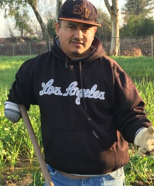 Rosendo Ramirez standing with hoe in a field