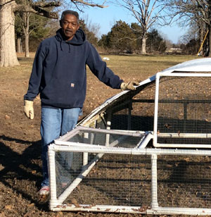Keith Raspberry standing next to portable chicken coop