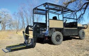 Buddy Buggy utility vehicle with wheelchair lift on back extended to the ground