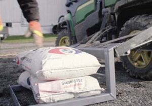 Strong Arm lift on side of UTV with seed bags stacked on it.