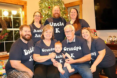 Family photo: Front: son Drew, Sheila, grandson Kael, Mike, daughter-in-law Selene. Back: daughter-in-law Anne Marie, son Tyson, daughter Ashley.