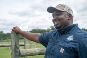 Davon Goodwin smiling while leaning on fence post