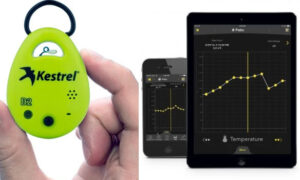 Heat monitor resembling car key fob next to tow data printouts on electronic devices