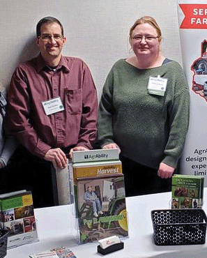 Ned Stoller stands next to Tiffany Jones behind display table with publications on it